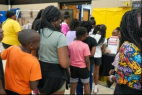 Group of people, including children, standing in a line for awareness